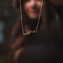 An elegant Arabic Name Silver Necklace featuring a delicate script pendant on a sleek cable chain, packaged in a luxury Jewel Flairs box.

