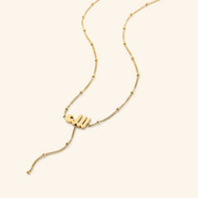 A silver lariat necklace featuring a dotted chain and Allah pendant, designed for a chic and meaningful look.

