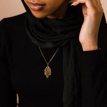 A beautifully designed silver necklace featuring Arabic calligraphy of the verse 