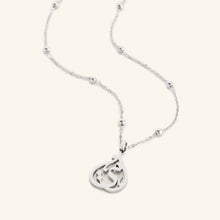 A cradled silver necklace featuring the Arabic calligraphy for 