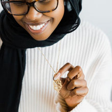 A silver dotted chain necklace featuring Arabic calligraphy of the Qur’anic verse 