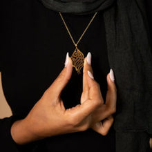 A beautifully designed silver necklace featuring Arabic calligraphy of the verse 