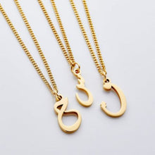 A silver curb chain necklace featuring a customizable hanging Arabic letter, worn at a 16-inch length.

