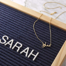 An elegant Arabic Name Silver Necklace featuring a delicate script pendant on a sleek cable chain, packaged in a luxury Jewel Flairs box.

