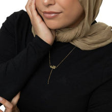 A silver lariat necklace featuring a dotted chain and Allah pendant, designed for a chic and meaningful look.

