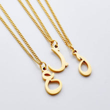 A silver curb chain necklace featuring a customizable hanging Arabic letter, worn at a 16-inch length.

