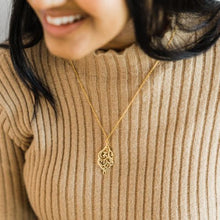 A silver dotted chain necklace featuring Arabic calligraphy of the Qur’anic verse 