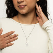 A sleek silver necklace featuring the Quranic verse 