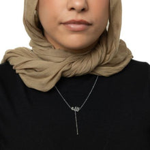 A silver lariat necklace featuring a dotted chain and Allah pendant, designed for a chic and meaningful look.

