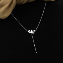 A silver lariat necklace featuring a dotted chain and Allah pendant, designed for a chic and meaningful look.

