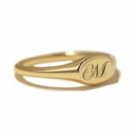 A classic personalized oval signet ring in 18k gold-plated sterling silver, engraved with a 'J' monogram and worn on a finger.