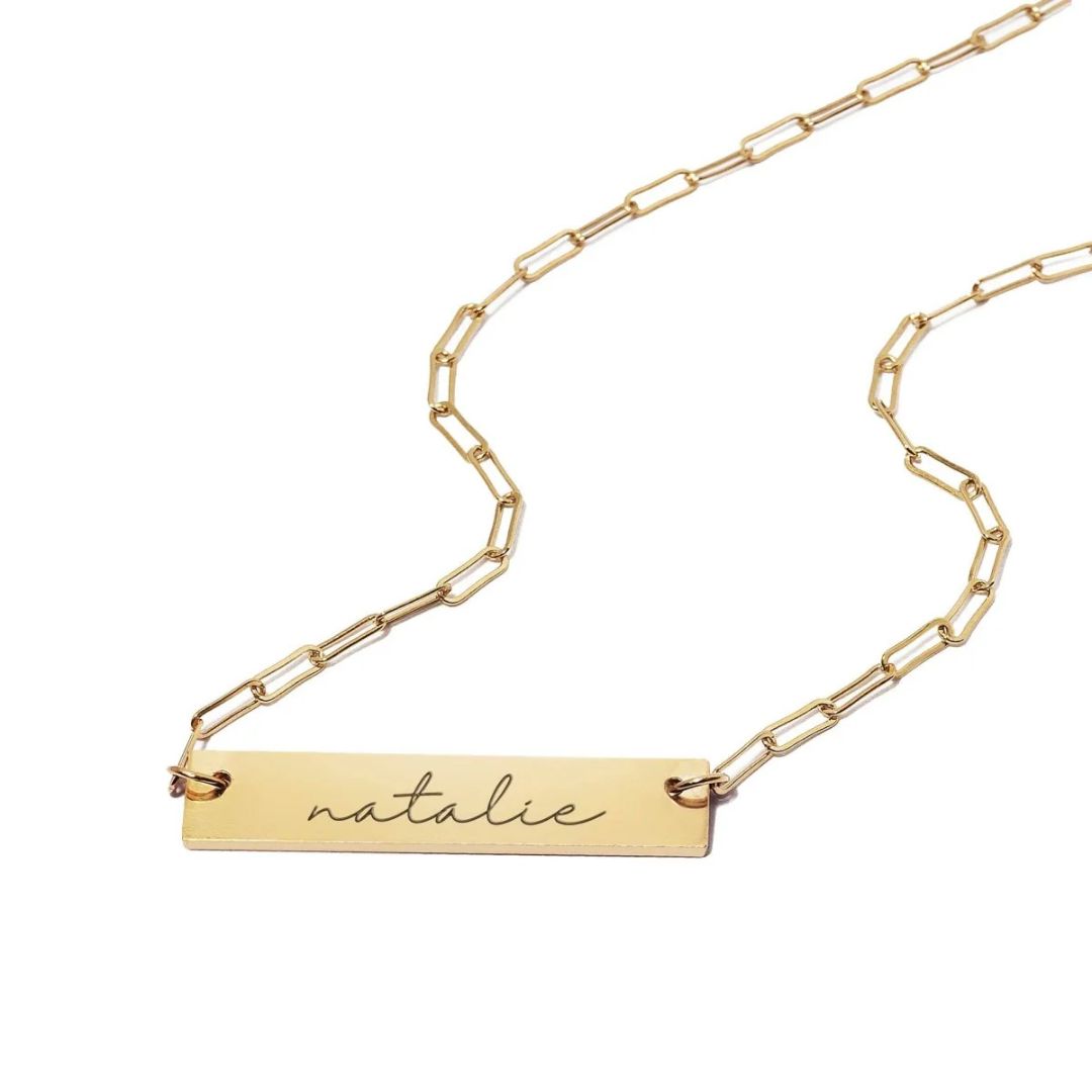 A personalized horizontal bar necklace in 18k gold-plated sterling silver, engraved with the name 'Amelia', on a delicate chain.