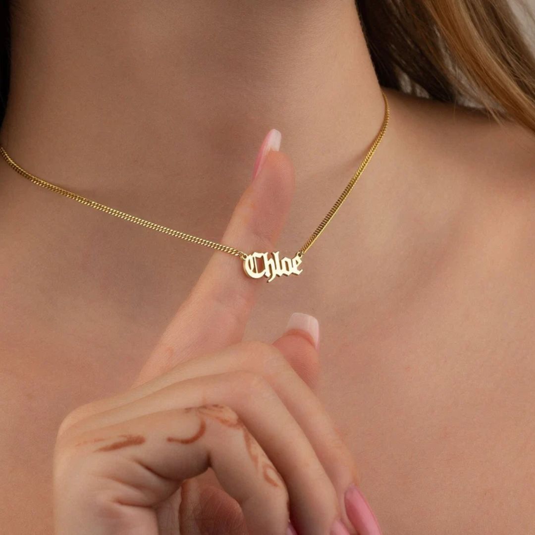 Gothic name necklace with the name 'Lilith' in Old English script, made from 18k rose gold-plated sterling silver on a curb chain.