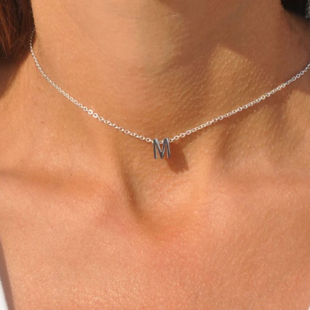 Floating initial 'K' necklace in 18k gold-plated sterling silver, showing the unique sideways letter integrated into the delicate chain.