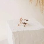 Personalized two-name ring in 18k rose gold-plated sterling silver, showing the names 'Noah' and 'Emma' on the open band design.