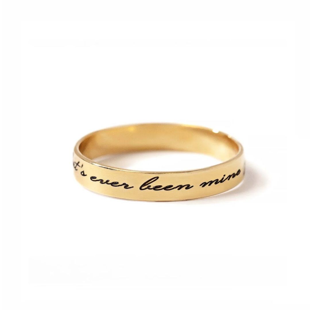 A personalized message ring in 18k gold-plated sterling silver, worn on a finger and engraved with the words 'Je t'aime'.