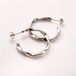 A pair of Liquid Ripple Hoop Earrings in 18k gold-plated sterling silver, showcasing their unique textured, light-catching surface.