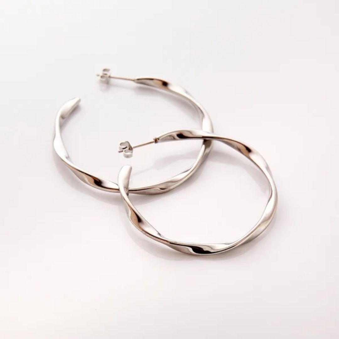 A pair of Liquid Ripple Hoop Earrings in 18k gold-plated sterling silver, showcasing their unique textured, light-catching surface.