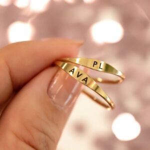 A dainty personalized signet ring in 18k gold-plated sterling silver, engraved with the initial 'S' and worn on a finger.
