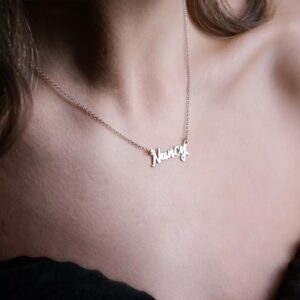 Personalized 'Olivia' name necklace in 18k rose gold-plated sterling silver, hanging from a delicate chain on a neutral background.