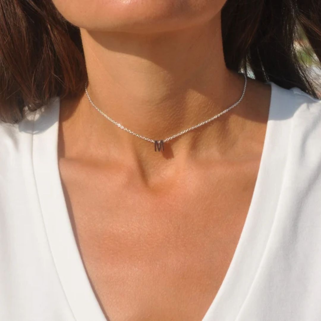 Floating initial 'K' necklace in 18k gold-plated sterling silver, showing the unique sideways letter integrated into the delicate chain.