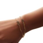 A bold initial 'B' curb chain bracelet in 18k gold-plated sterling silver, worn on a wrist to show its style and substantial fit.