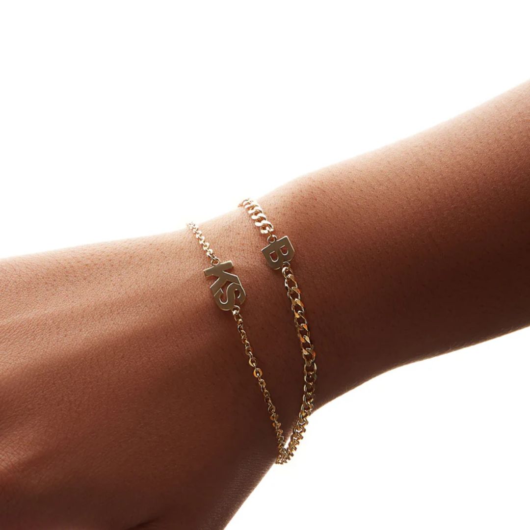 A bold initial 'B' curb chain bracelet in 18k gold-plated sterling silver, worn on a wrist to show its style and substantial fit.