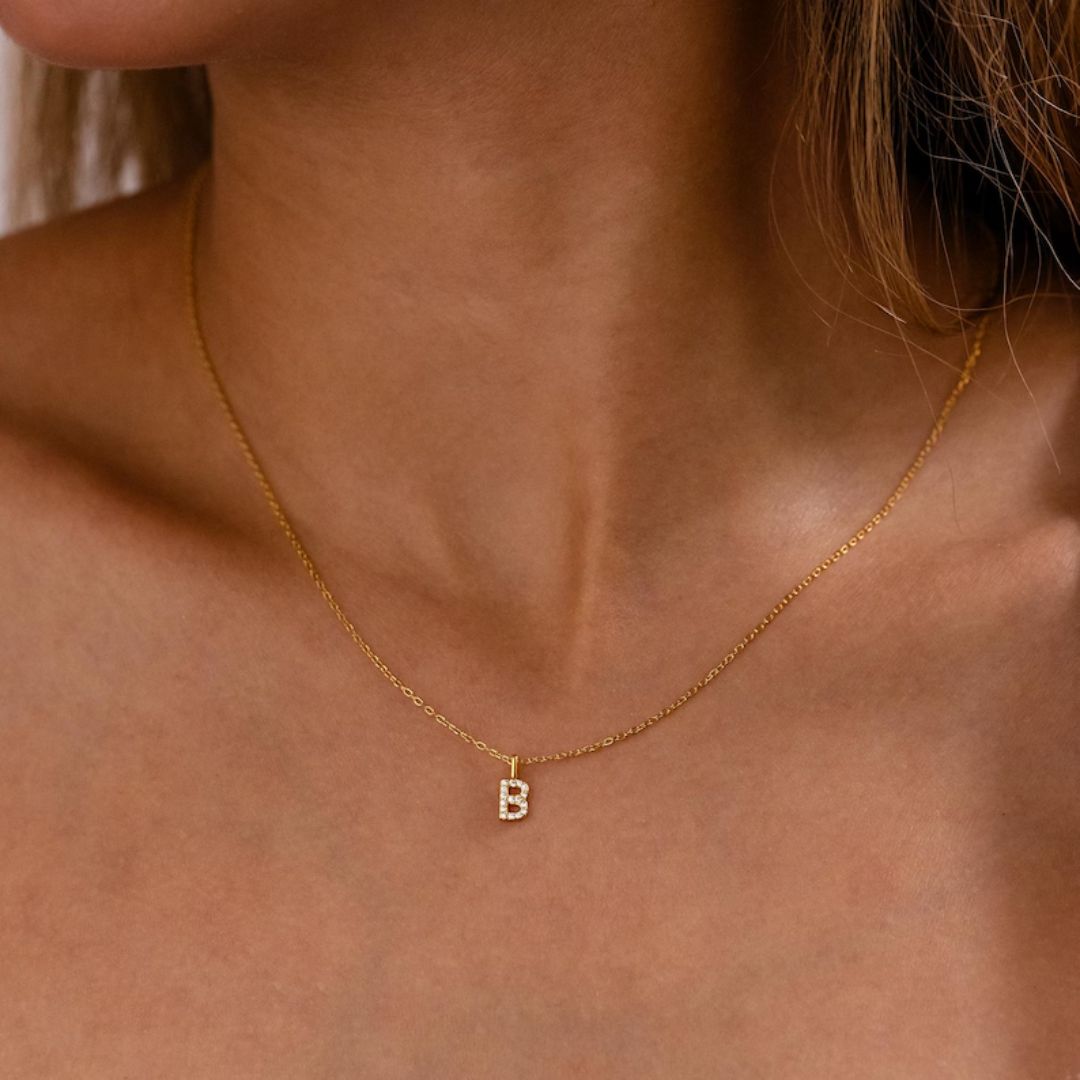 Dazzling pave initial 'M' necklace in 18k gold-plated sterling silver, sparkling on a delicate chain.