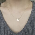 Luna Crescent Moon necklace in 18k gold-plated sterling silver, showing the polished pendant on a delicate chain.