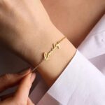 Dainty 'Sophia' name bracelet in 18k gold-plated sterling silver, worn on a woman's wrist.
