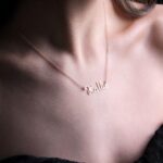 Personalized 'Olivia' name necklace in 18k rose gold-plated sterling silver, hanging from a delicate chain on a neutral background.