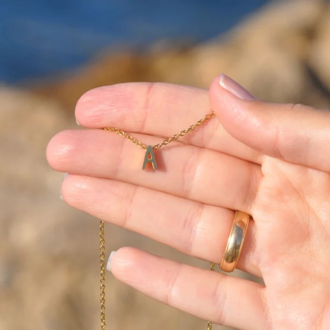 Floating initial 'K' necklace in 18k gold-plated sterling silver, showing the unique sideways letter integrated into the delicate chain.