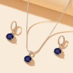 The Royal Sapphire Halo Jewelry Set in sterling silver, showing the matching necklace and earrings with their deep blue central stones and surrounding crystal halos.