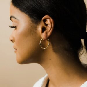 A pair of Liquid Ripple Hoop Earrings in 18k gold-plated sterling silver, showcasing their unique textured, light-catching surface.