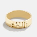 A personalized 14k solid gold ring, engraved with the name 'Elizabeth', shown on a woman's finger.