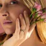 A dainty personalized heart initial 'A' ring in 18k gold-plated sterling silver, worn on a woman's finger.