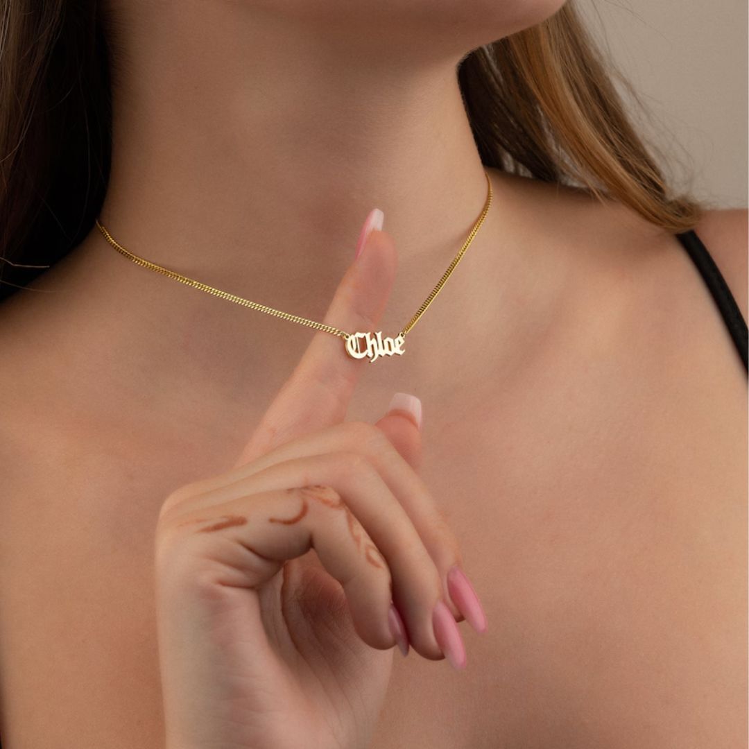 Gothic name necklace with the name 'Lilith' in Old English script, made from 18k rose gold-plated sterling silver on a curb chain.