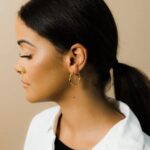 A pair of Liquid Ripple Hoop Earrings in 18k gold-plated sterling silver, showcasing their unique textured, light-catching surface.