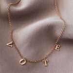 Dangling Family Initials Necklace in 18k gold-plated sterling silver, showing multiple letter charms (e.g., A, S, M) hanging from a delicate chain.