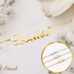 Personalized 'Olivia' name necklace in 18k rose gold-plated sterling silver, hanging from a delicate chain on a neutral background.