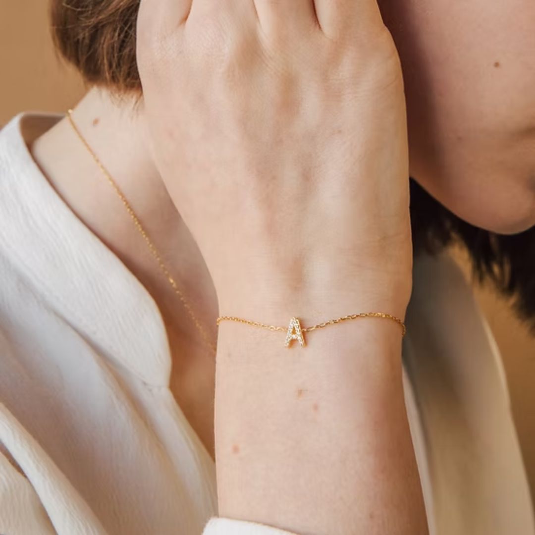 Dazzling pave initial 'A' bracelet in 18k gold-plated sterling silver, sparkling on a woman's wrist.