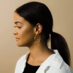 A pair of Liquid Ripple Hoop Earrings in 18k gold-plated sterling silver, showcasing their unique textured, light-catching surface.
