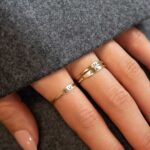 A dainty personalized signet ring in 18k gold-plated sterling silver, engraved with the initial 'S' and worn on a finger.