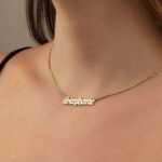 Gothic name necklace with the name 'Lilith' in Old English script, made from 18k rose gold-plated sterling silver on a curb chain.
