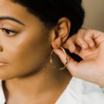 A pair of Liquid Ripple Hoop Earrings in 18k gold-plated sterling silver, showcasing their unique textured, light-catching surface.