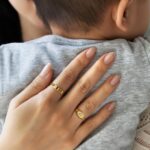A classic personalized oval signet ring in 18k gold-plated sterling silver, engraved with a 'J' monogram and worn on a finger.