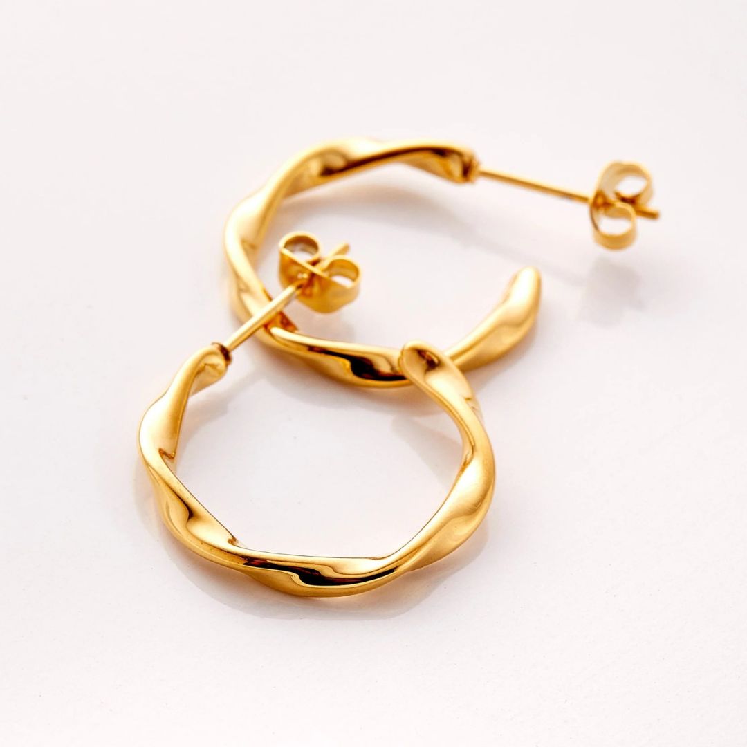 A pair of Liquid Ripple Hoop Earrings in 18k gold-plated sterling silver, showcasing their unique textured, light-catching surface.