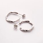 A pair of Liquid Ripple Hoop Earrings in 18k gold-plated sterling silver, showcasing their unique textured, light-catching surface.