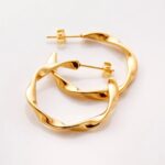 A pair of Liquid Ripple Hoop Earrings in 18k gold-plated sterling silver, showcasing their unique textured, light-catching surface.