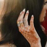 'Yusr' (Ease) Arabic calligraphy signet ring in 18k gold-plated sterling silver, worn on a finger to showcase the engraved face.
